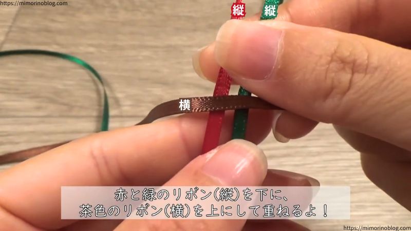 Xグリーンとアカを縦にして、その上にココアを横にして重ねてください。
2つの十字ができるようなイメージでリボンを並べます。